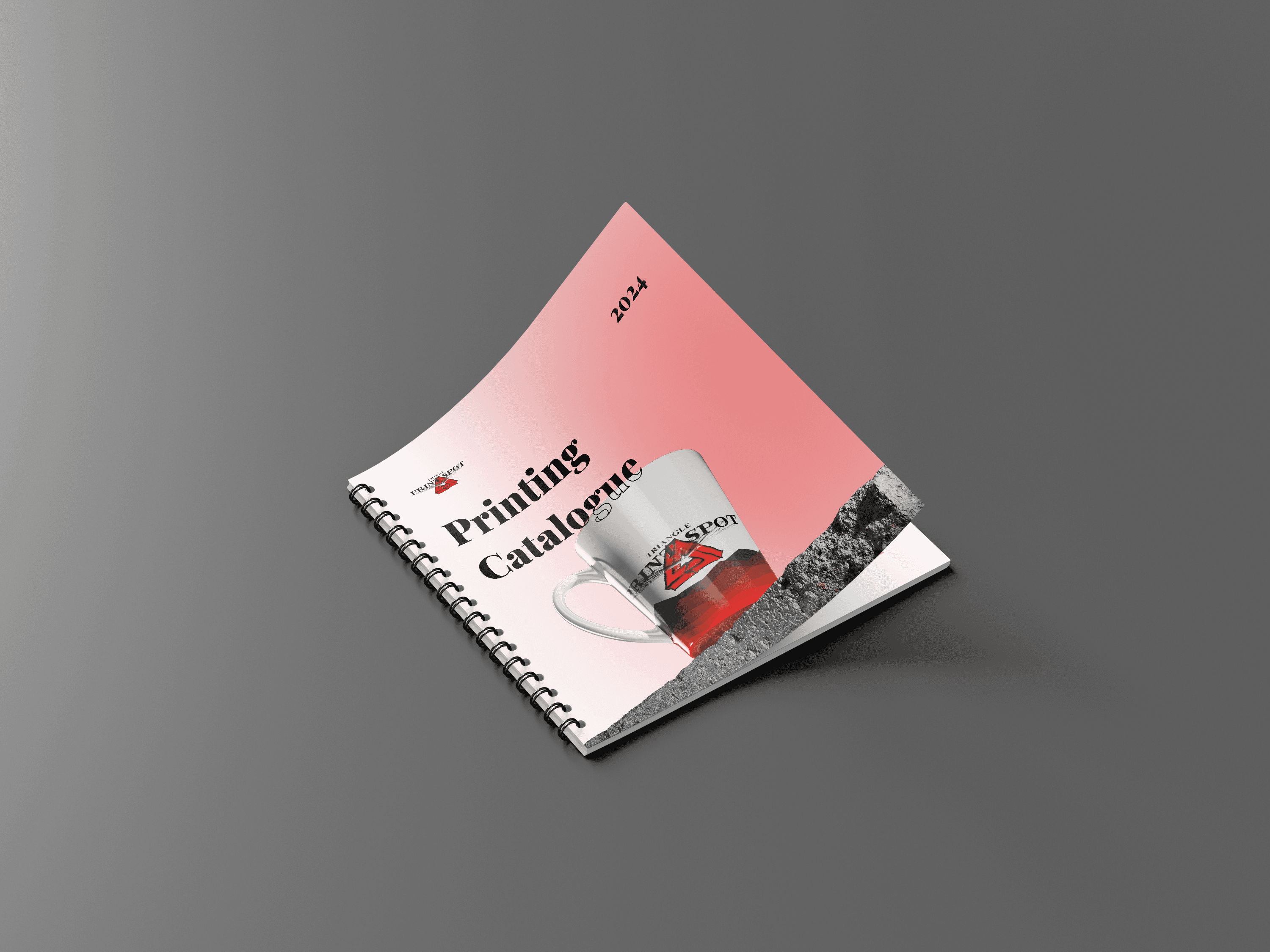 A ring-bound book with a red cover featuring a mug image, set against a plain grey background.