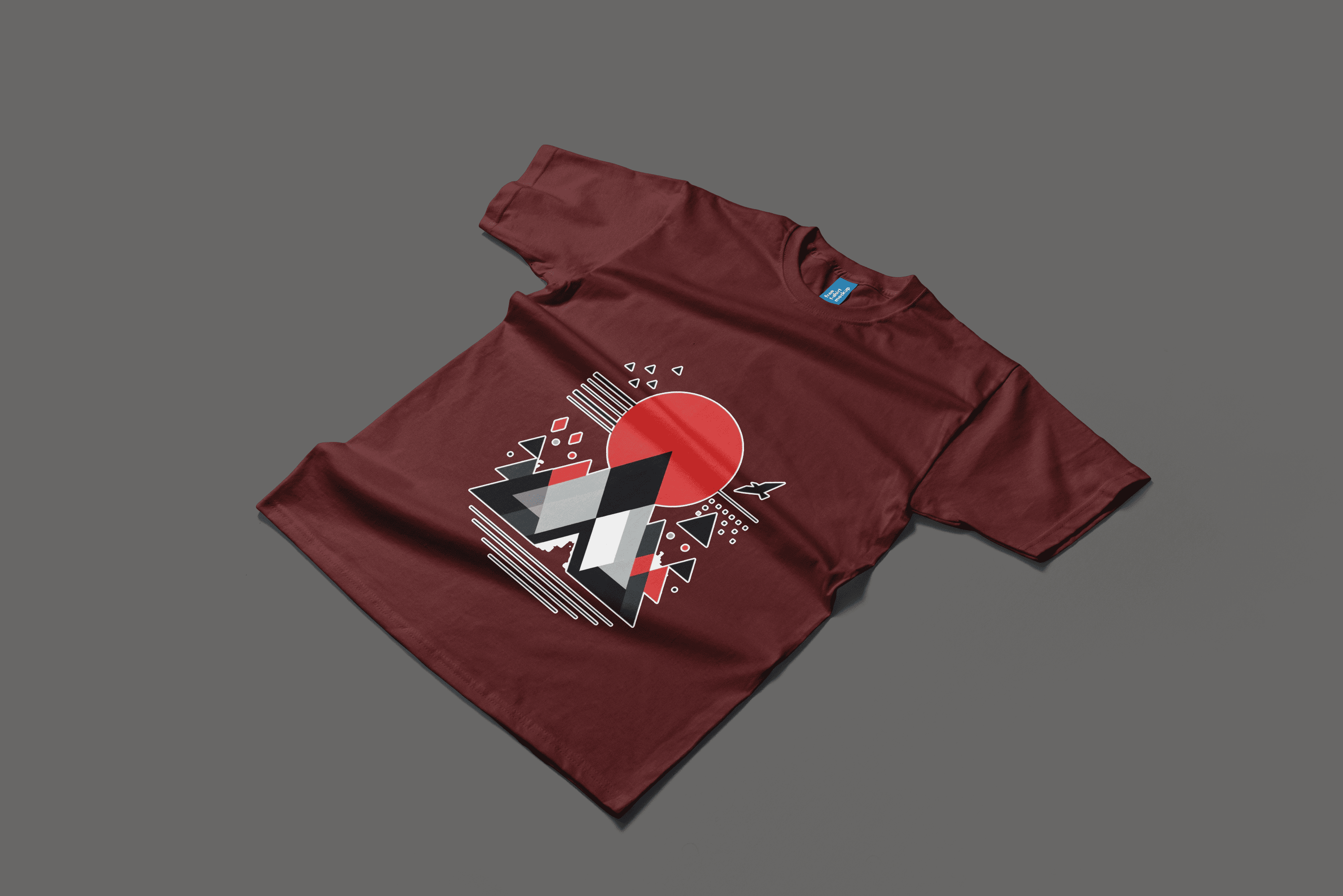 A maroon t-shirt displaying a red triangle and mountain motif, combining minimalist design with an adventurous spirit.
